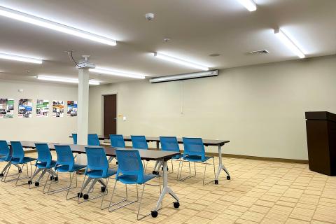 A large room with tables and chairs, suitable for meetings or presentations