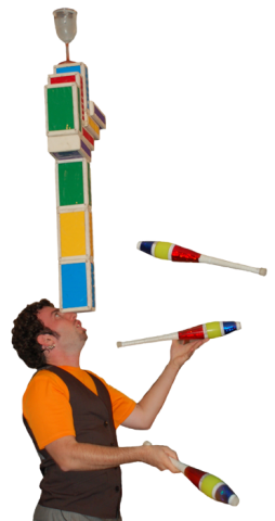 A man juggling three clubs while balancing a tower of blocks on his nose.  