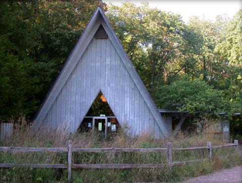 An A-frame building in a wooded setting.