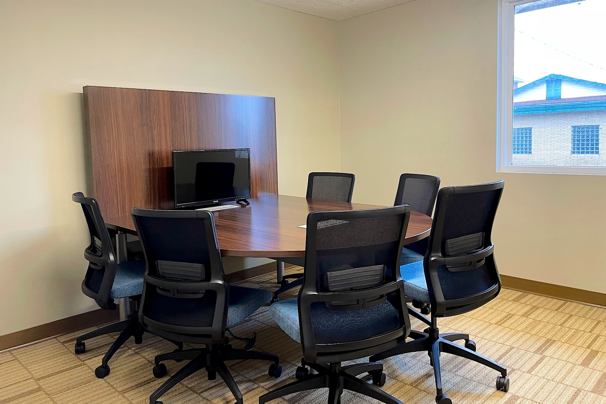 A room with a horseshoe table and six rolling task chairs