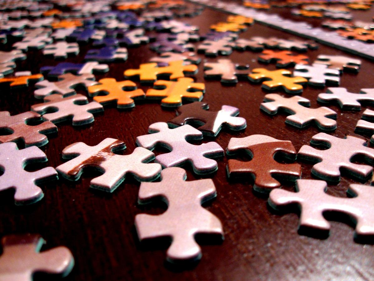 Jigsaw puzzle pieces randomly scattered on a table